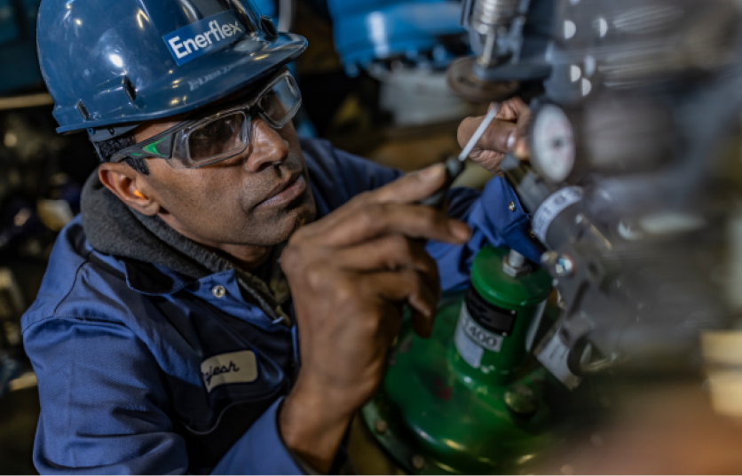 An Enerflex employee performing a task while wearing a hardhat