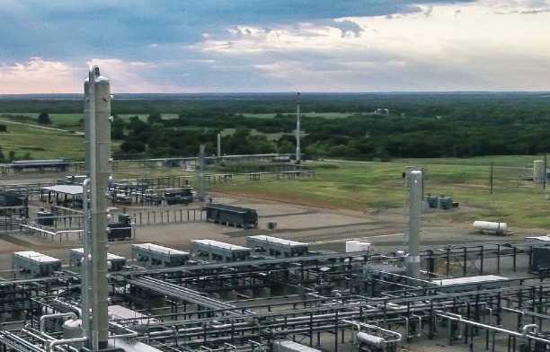 An Enerflex facility in the daytime with expansive countryside stretching into the distance.