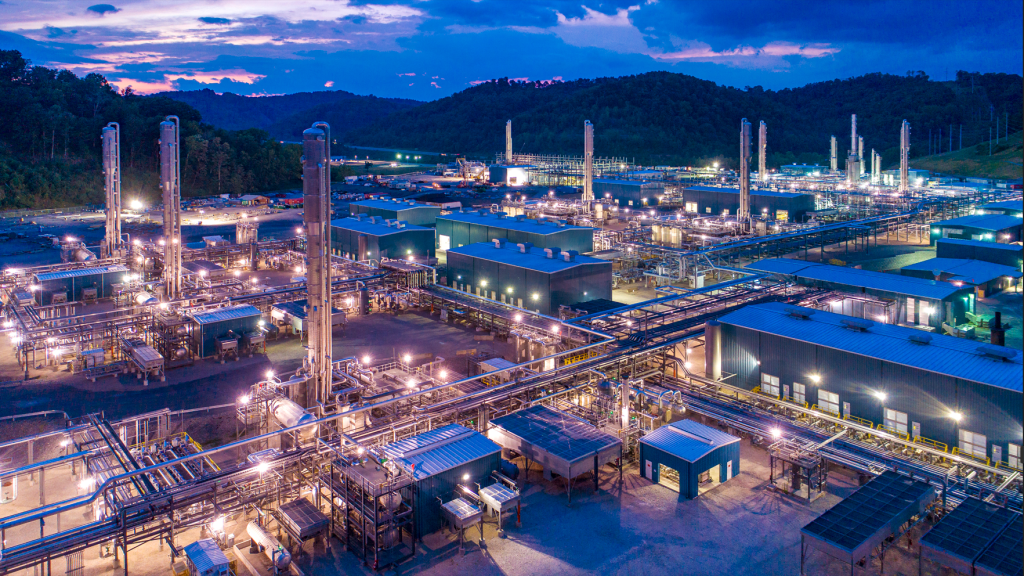 Enerflex facility illuminated at dusk with mountains in the background.